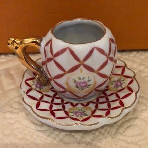 Pretty little collectible floral teacup and saucer set with gold trim and handle